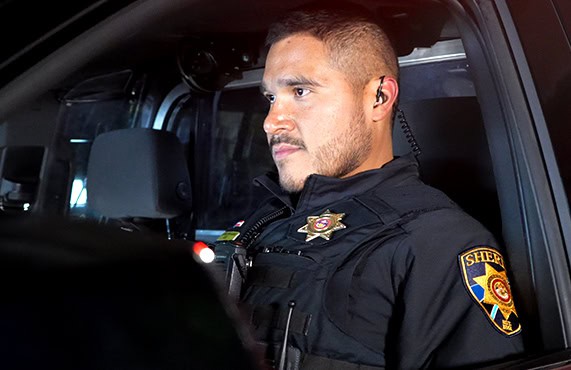 Douglas County Sheriff's Office officer in uniform inside patrol vehicle.